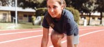 Une jeune femme dans les starting blocks sur une piste d'athlétisme